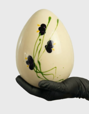 Rankų darbo baltasis šokoladinis Velykinis kiaušinis su dekoru rankoje